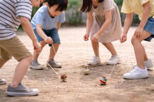 昔遊びの中で体を動かしながら関わり合う子どもたちの様子